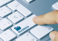 Das Bild zeigt einen Finger, der die Taste "Rückblick" auf einer Computertastatur drückt.